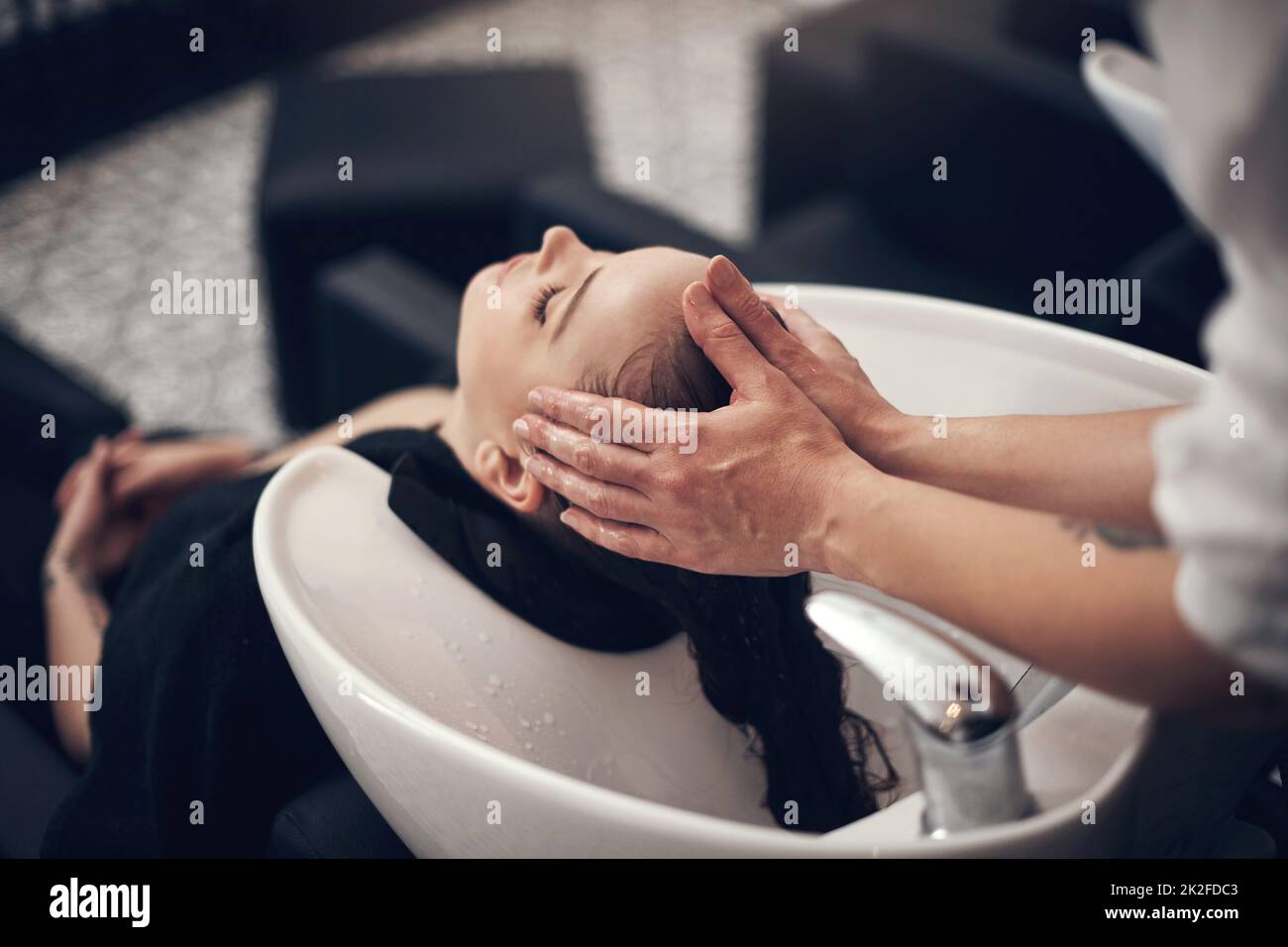 Schön aussehendes Haar beginnt mit einem wirklich guten Shampoo. Aufnahme einer schönen jungen Frau, die im Salon ihre Haare waschen ließ. Stockfoto