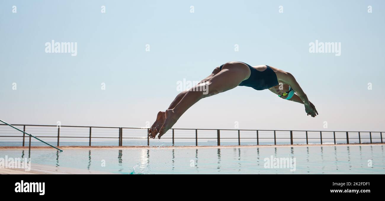 Heute haben Sie 100 Ihres Lebens übrig. Aufnahme eines jungen Sportlers, der in einen Pool in olypmischer Größe taucht. Stockfoto