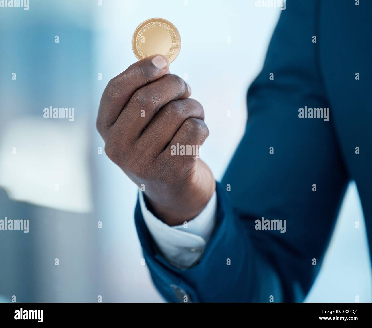 Es ist so viel mehr als nur eine Münze. Aufnahme eines Geschäftsmannes, der in einem modernen Büro eine Bitcoin hält. Stockfoto