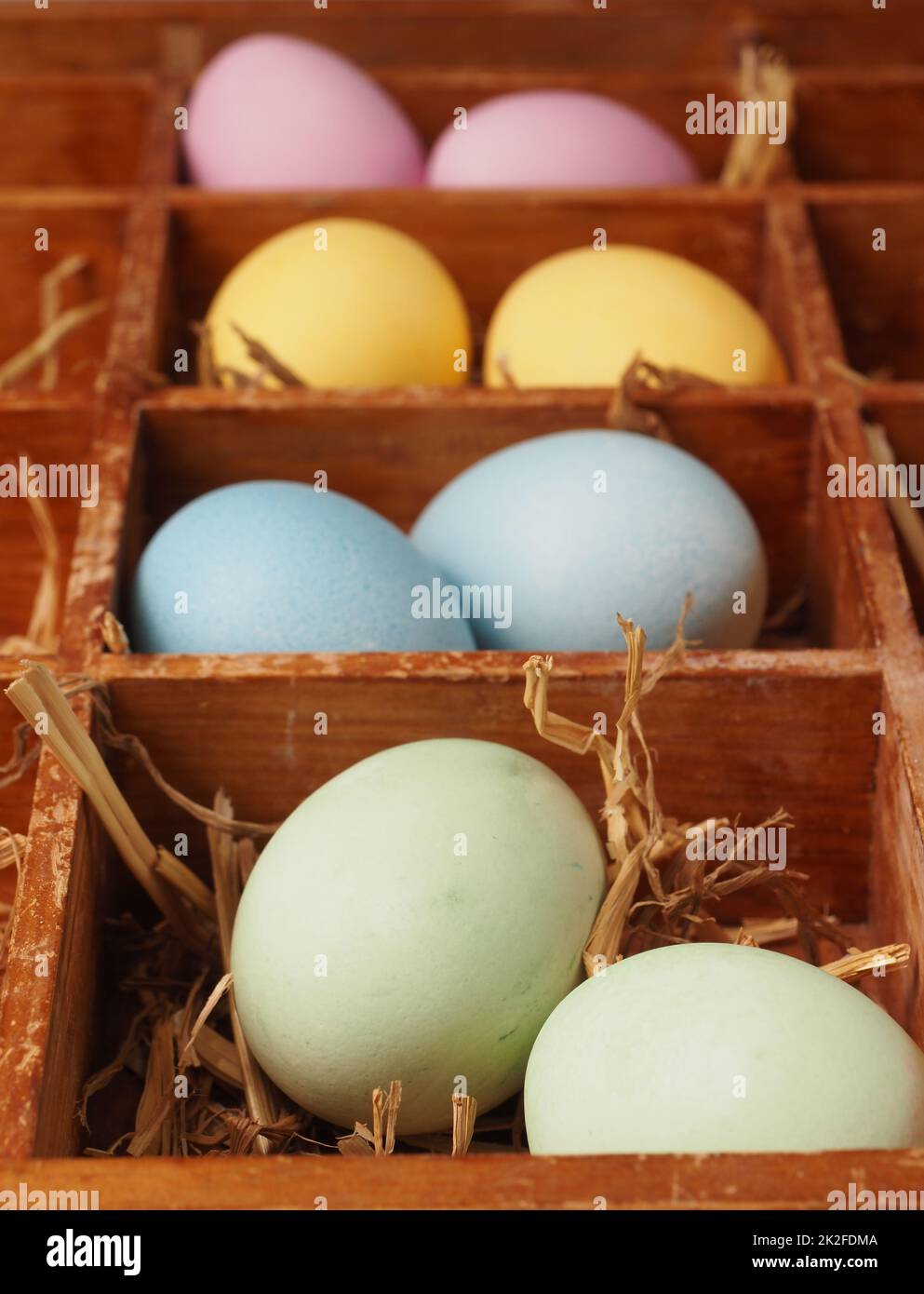 Mit natürlichen Farbstoffen selbstgefärbte Bio-Eier in einem Strohnest Stockfoto