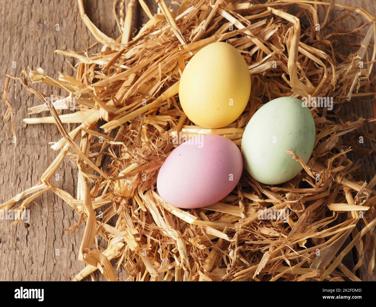 Mit natürlichen Farbstoffen selbstgefärbte Bio-Eier in einem Strohnest Stockfoto