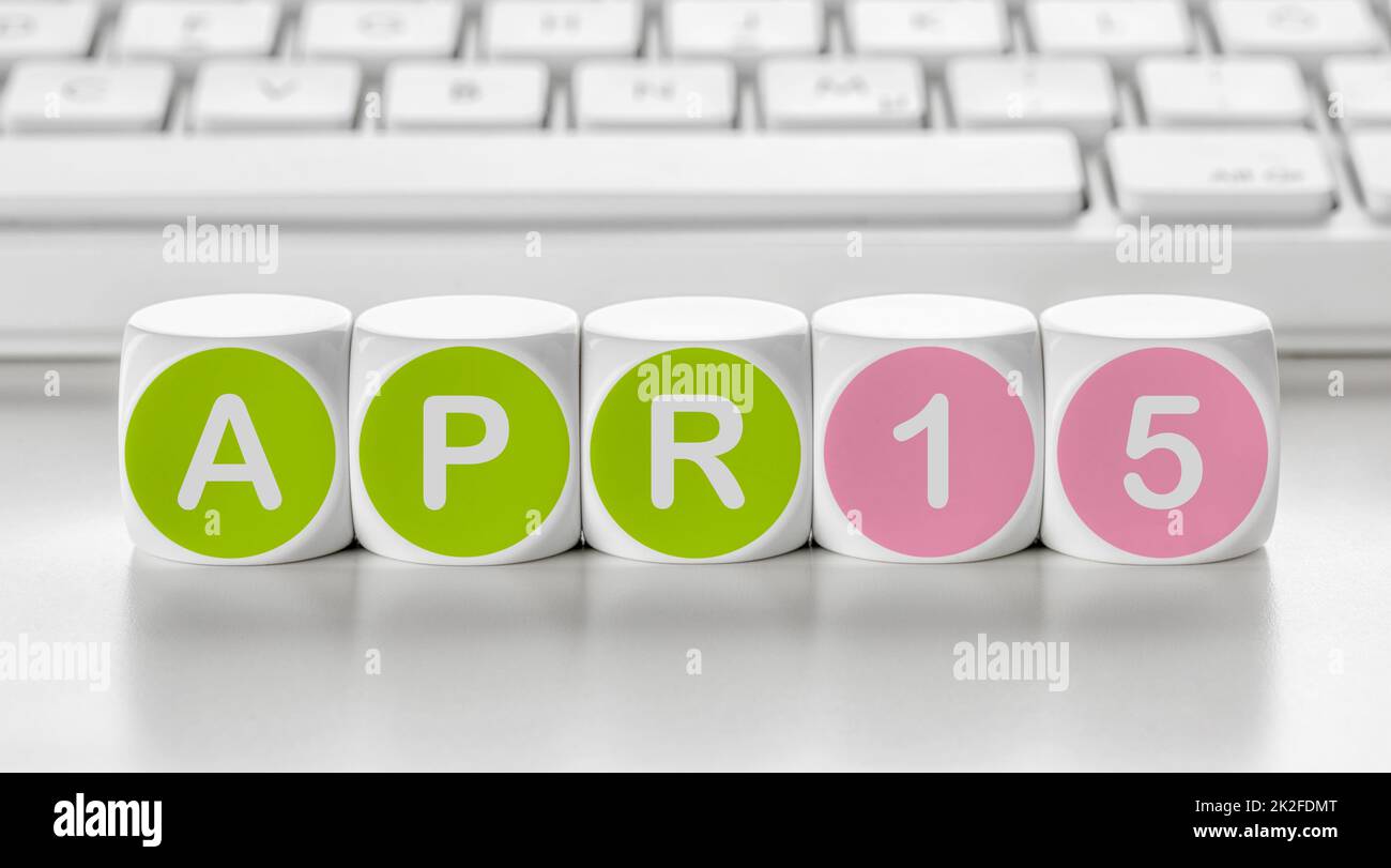 Buchstabenwürfel vor einer Tastatur - April 15 Stockfoto