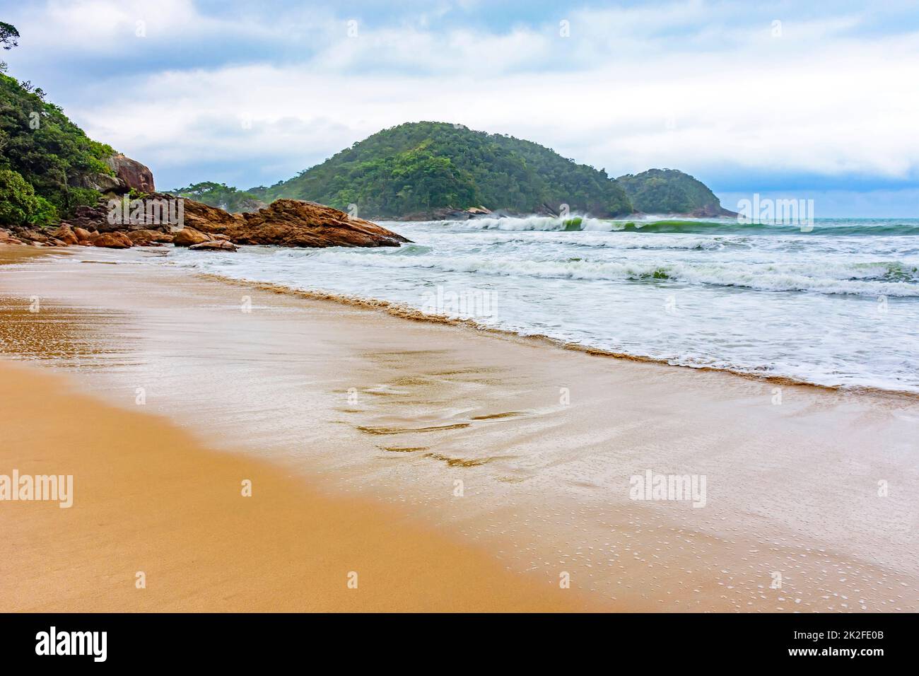 Menschenleerer Strand an regnerischen Tagen mit Wolken Stockfoto