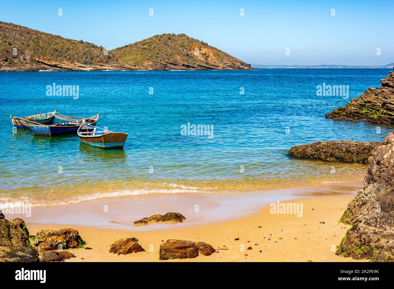 Altes hölzernes Fischerboot, das auf dem farbenfrohen und transparenten Wasser schwimmt Stockfoto