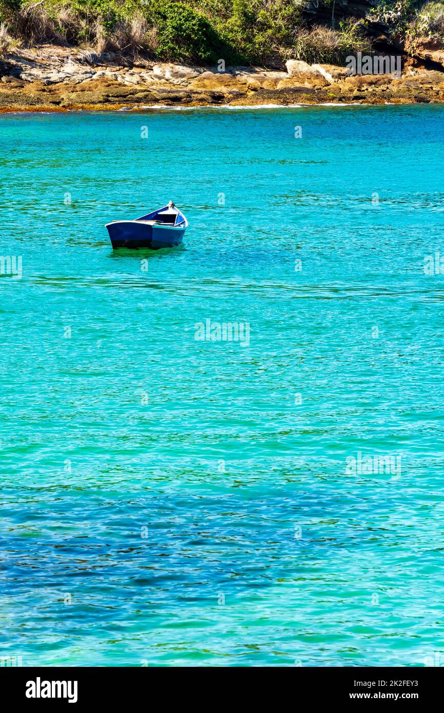 Hölzernes Fischerboot, das auf dem farbenfrohen und transparenten Wasser schwimmt Stockfoto