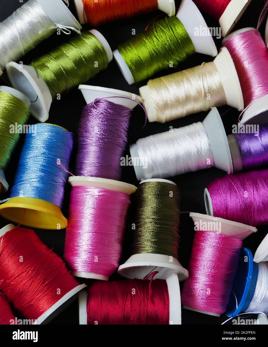 Nahaufnahme farbenfrohe Fäden, handgefertigte Fäden, farbenfrohe Strickfäden aus Spitze, gewickelt auf Spulen Stockfoto