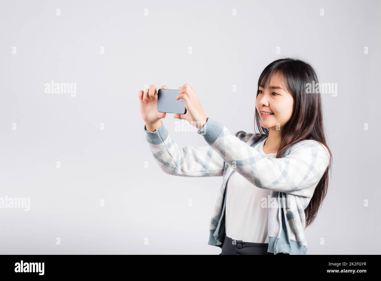 Frau begeistert, mit dem Smartphone Selfie-Fotos von der Frontkamera aufzunehmen Stockfoto