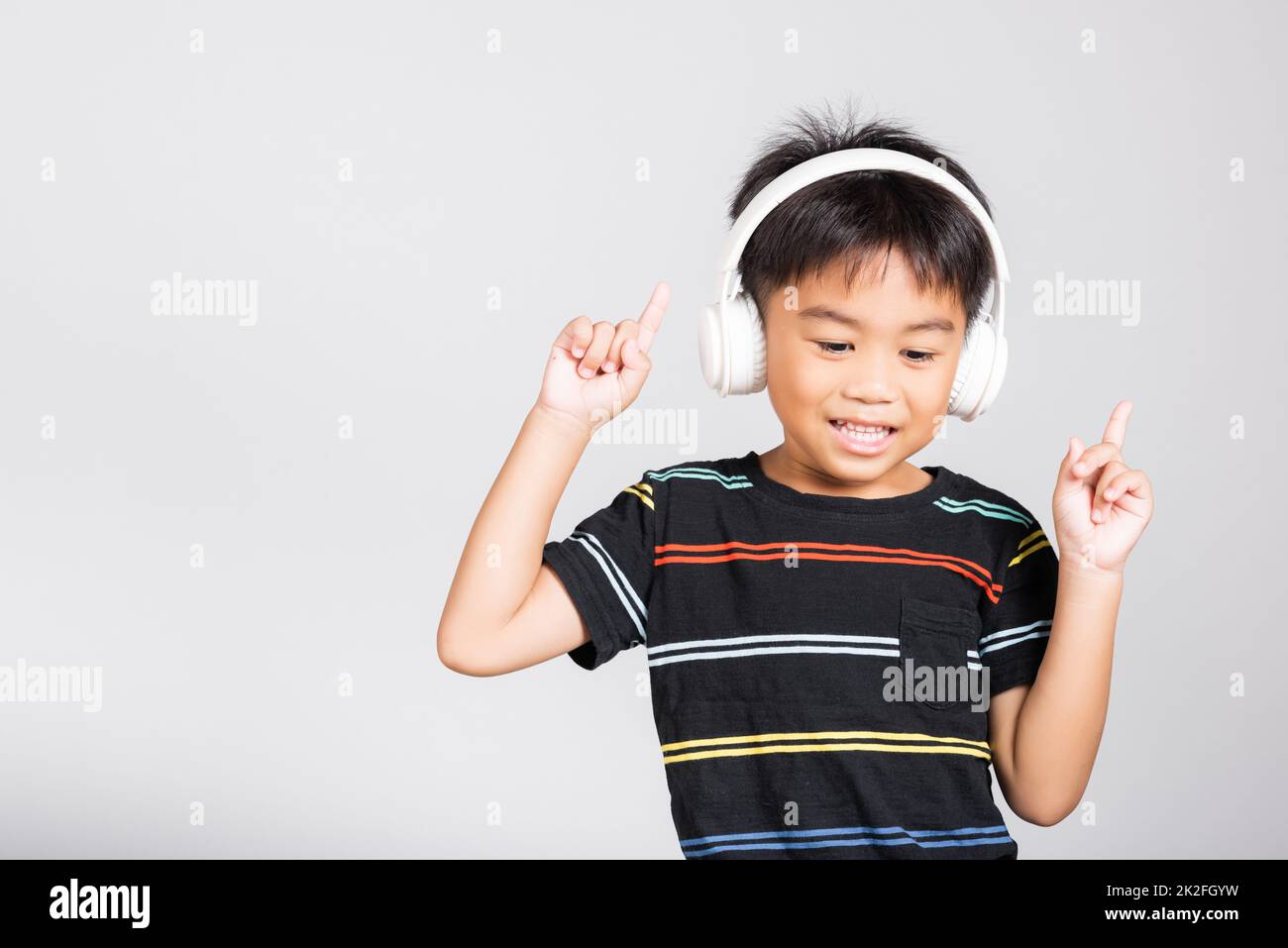Der kleine süße Junge im Alter von 5-6 Jahren hört Musik mit kabellosen Kopfhörern Stockfoto
