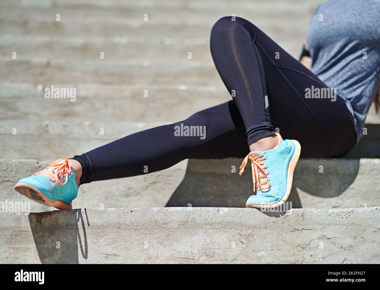 Schritte zu einem gesünderen Lebensstil. Eine kurze Aufnahme einer sportlichen jungen Frau, die draußen auf einer Treppe sitzt. Stockfoto