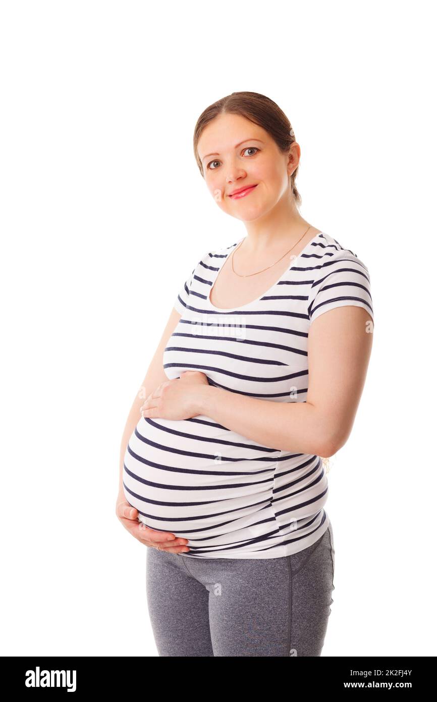 Eine Schwangerin steht und umarmt ihren Bauch Stockfoto