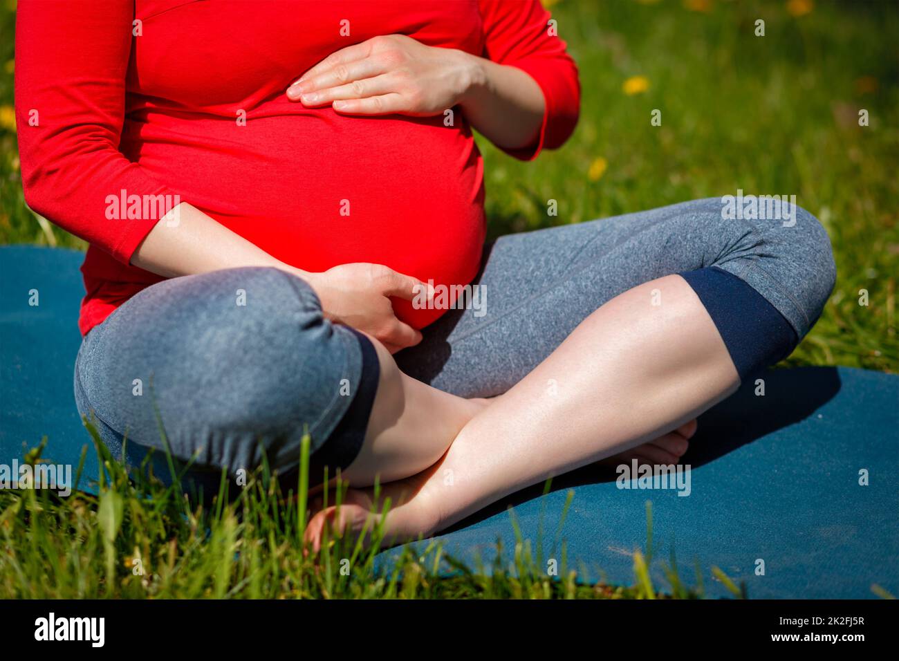 Schwangere, die im Freien Asana Sukhasana macht Stockfoto