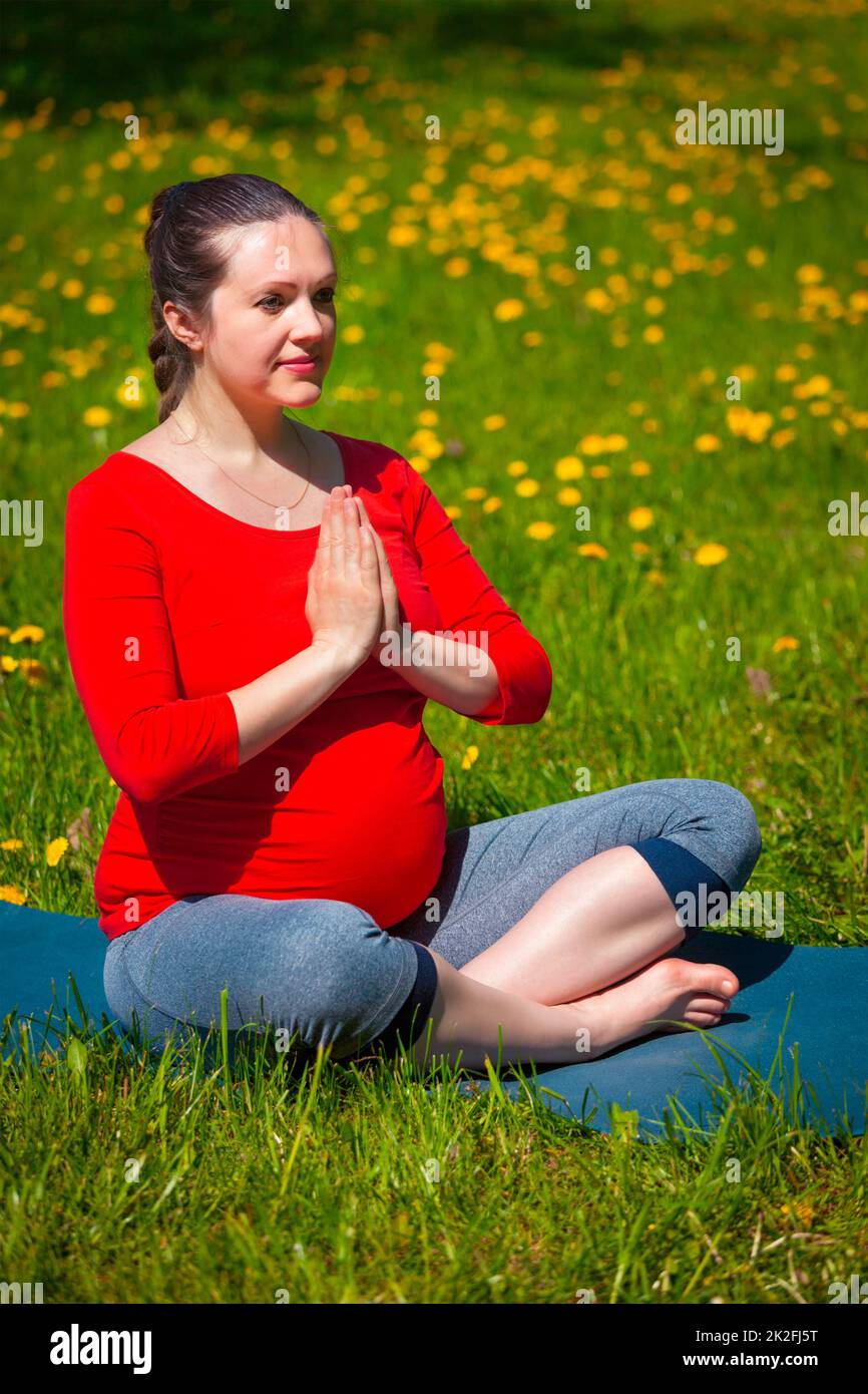 Schwangere, die im Freien Asana Sukhasana macht Stockfoto