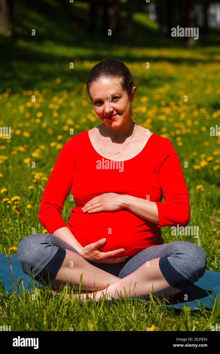 Schwangere, die im Freien Asana Sukhasana macht Stockfoto