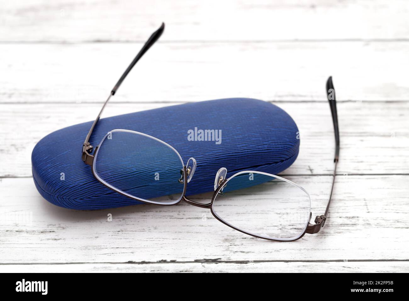 Stilvolle Brillen und Etui für Gläser auf weißem Holztisch Stockfoto