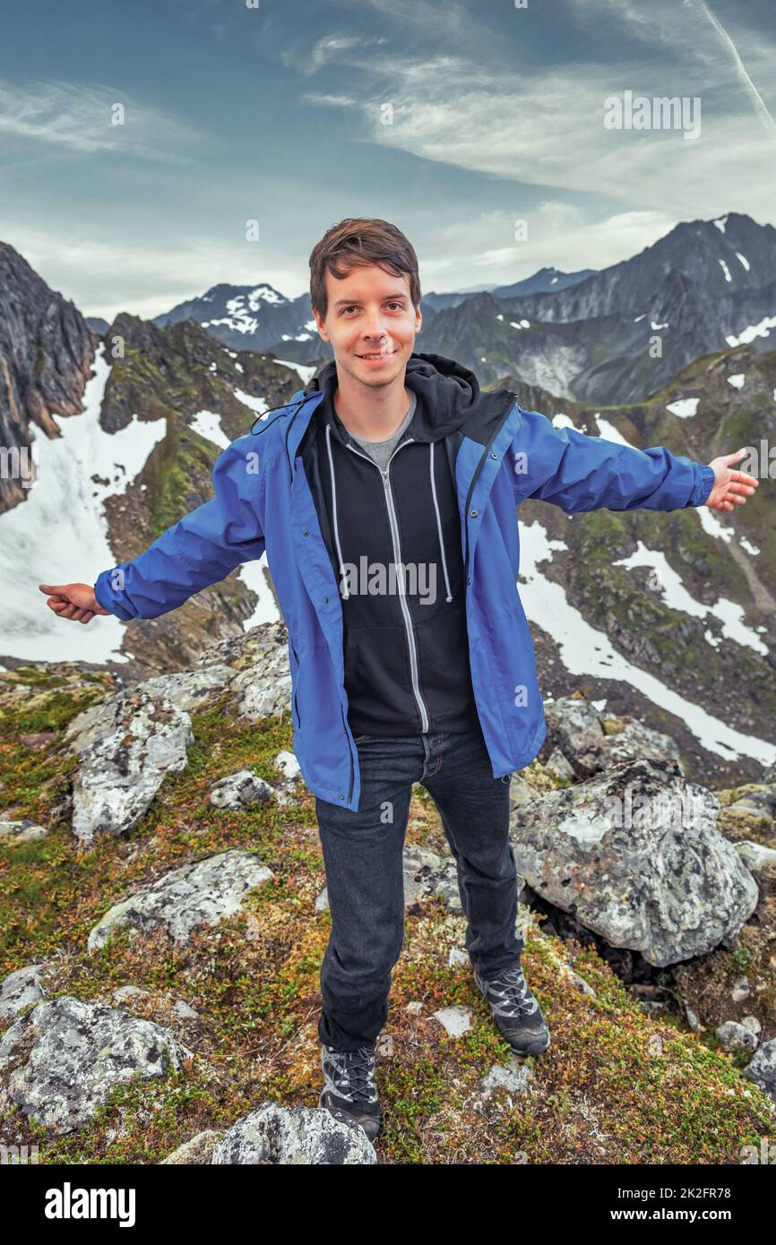 Ein Mann schaut in die Kamera, während er im Winter auf einem Berg steht Stockfoto
