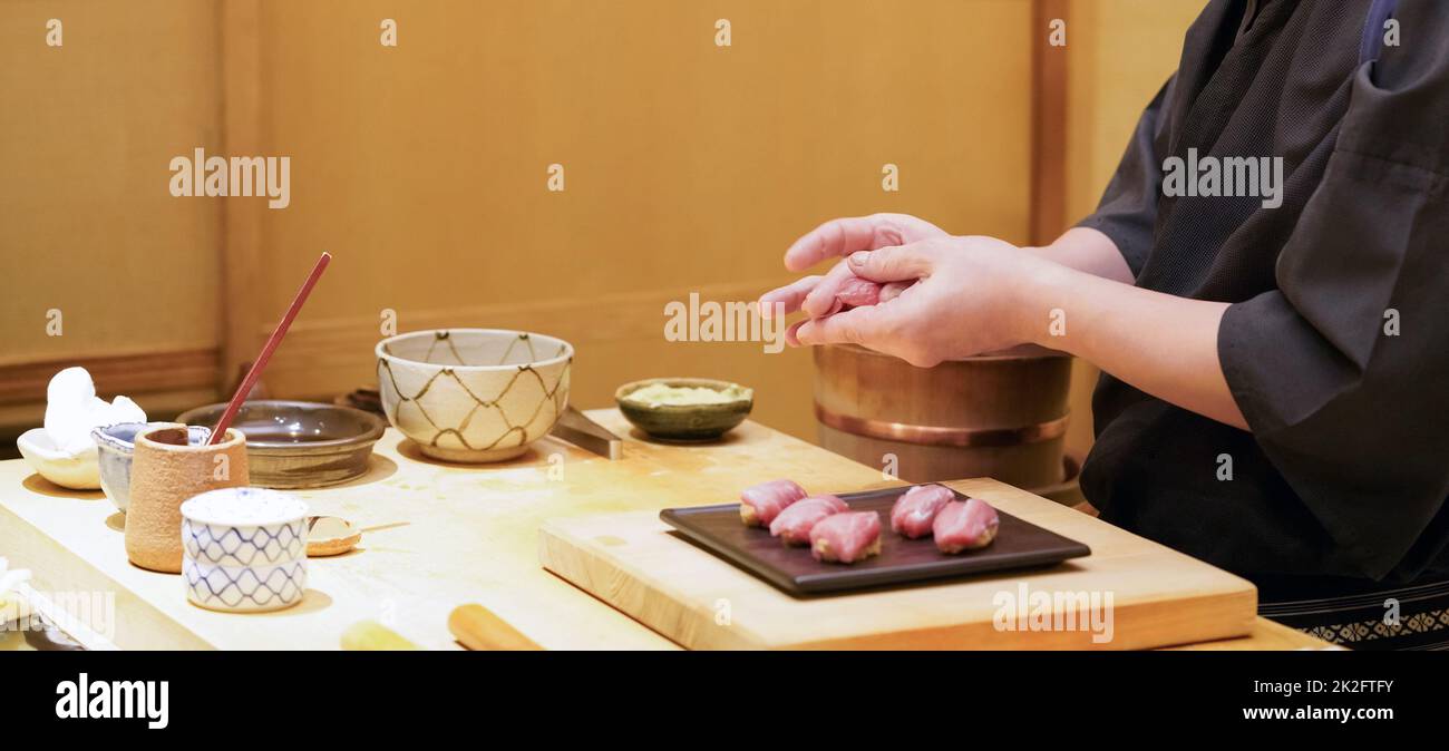 Küchenchef bereitet traditionelles Thunfisch-Sushi im Restaurant zu. Omakase Dining Atmosphäre. Stockfoto