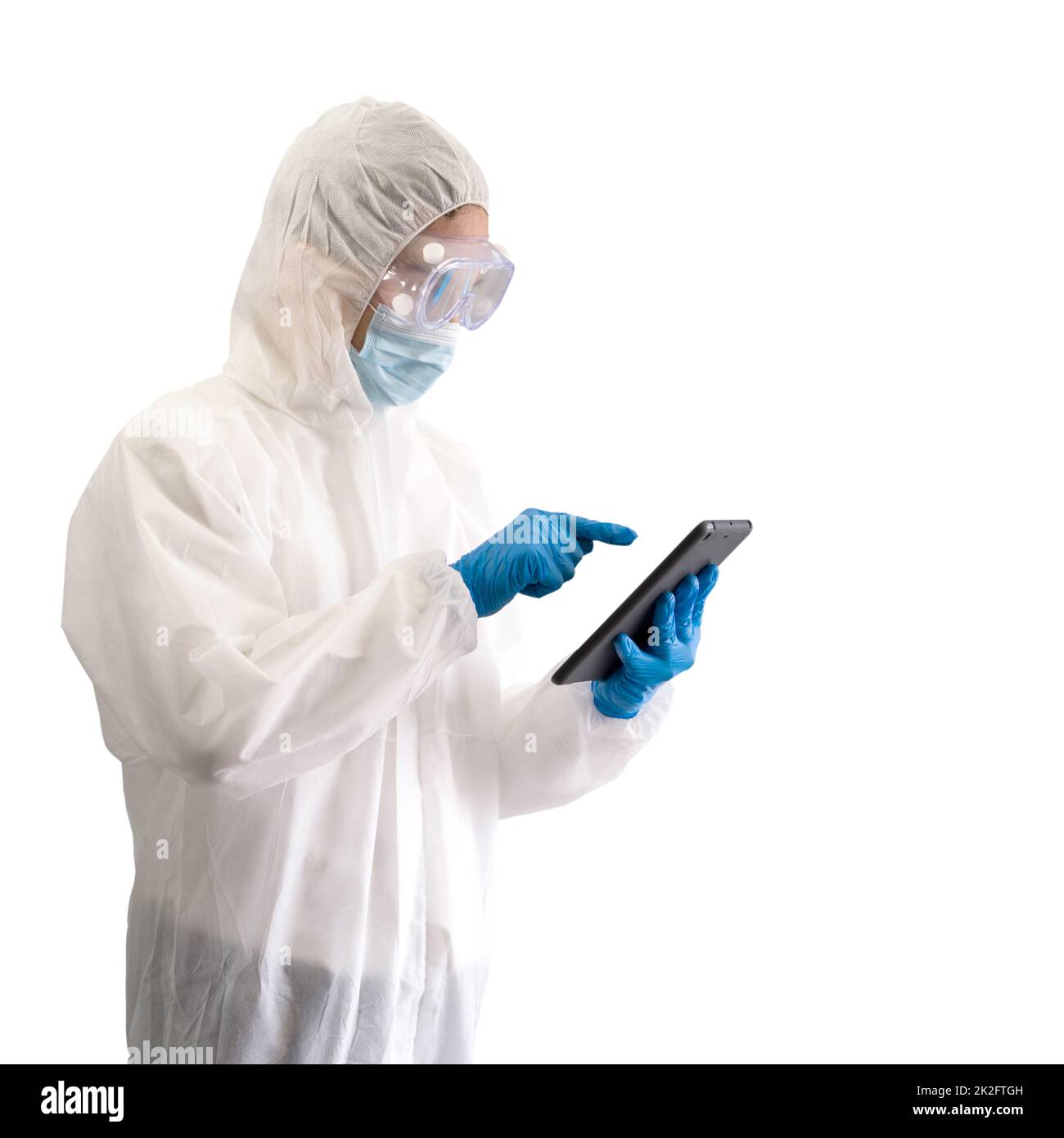 Epidemiologischer Forscher in Virusschutzkleidung, die auf einen Tablet-Computer-Monitor zeigt. Stockfoto