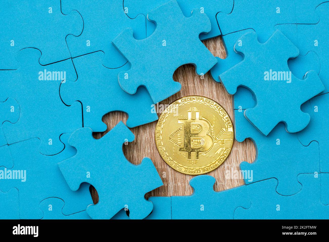 Puzzle-Muster mit goldenem Bitcoin darunter Stockfoto