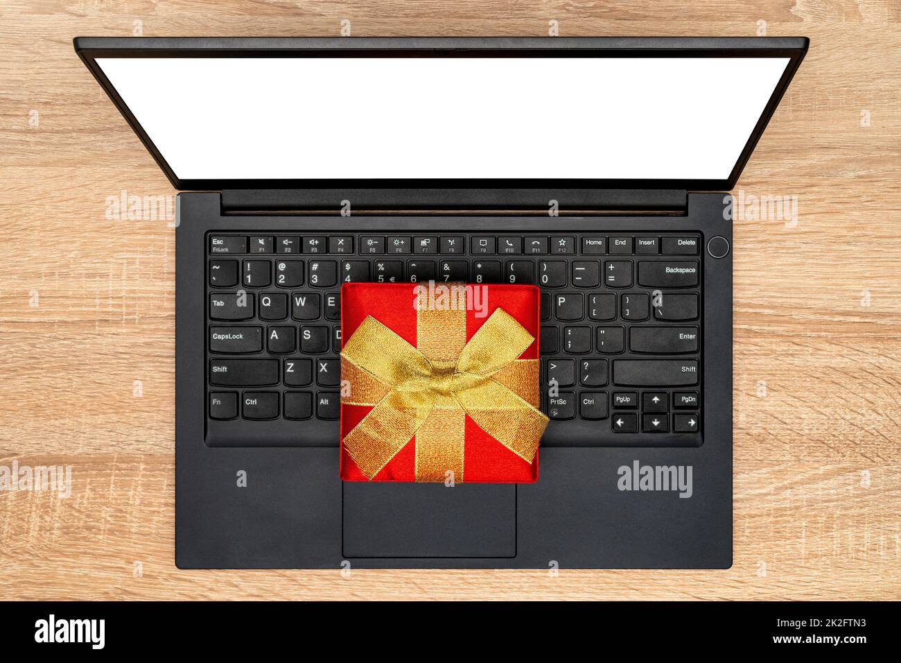 Moderner Laptop und rote Geschenkbox Stockfoto