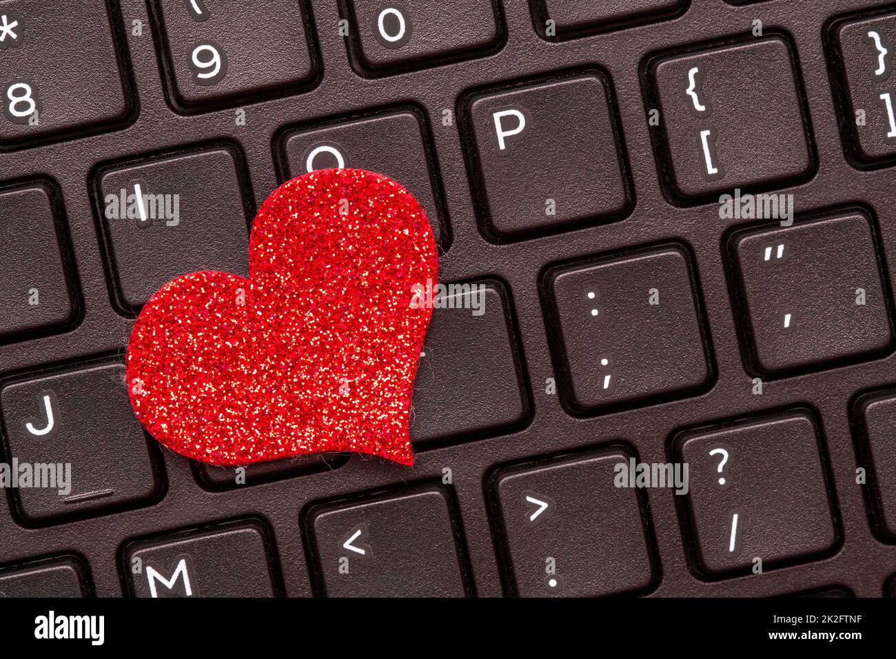 Ein rotes Herz auf einer Laptop-Tastatur Stockfoto