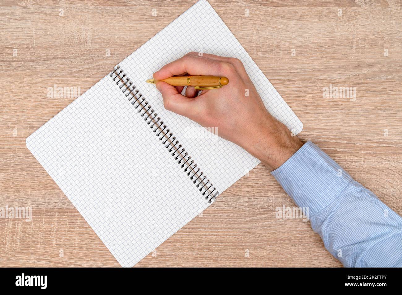 Draufsicht Männer handschriftlich mit einem Stift in Spiralnotizbuch Stockfoto