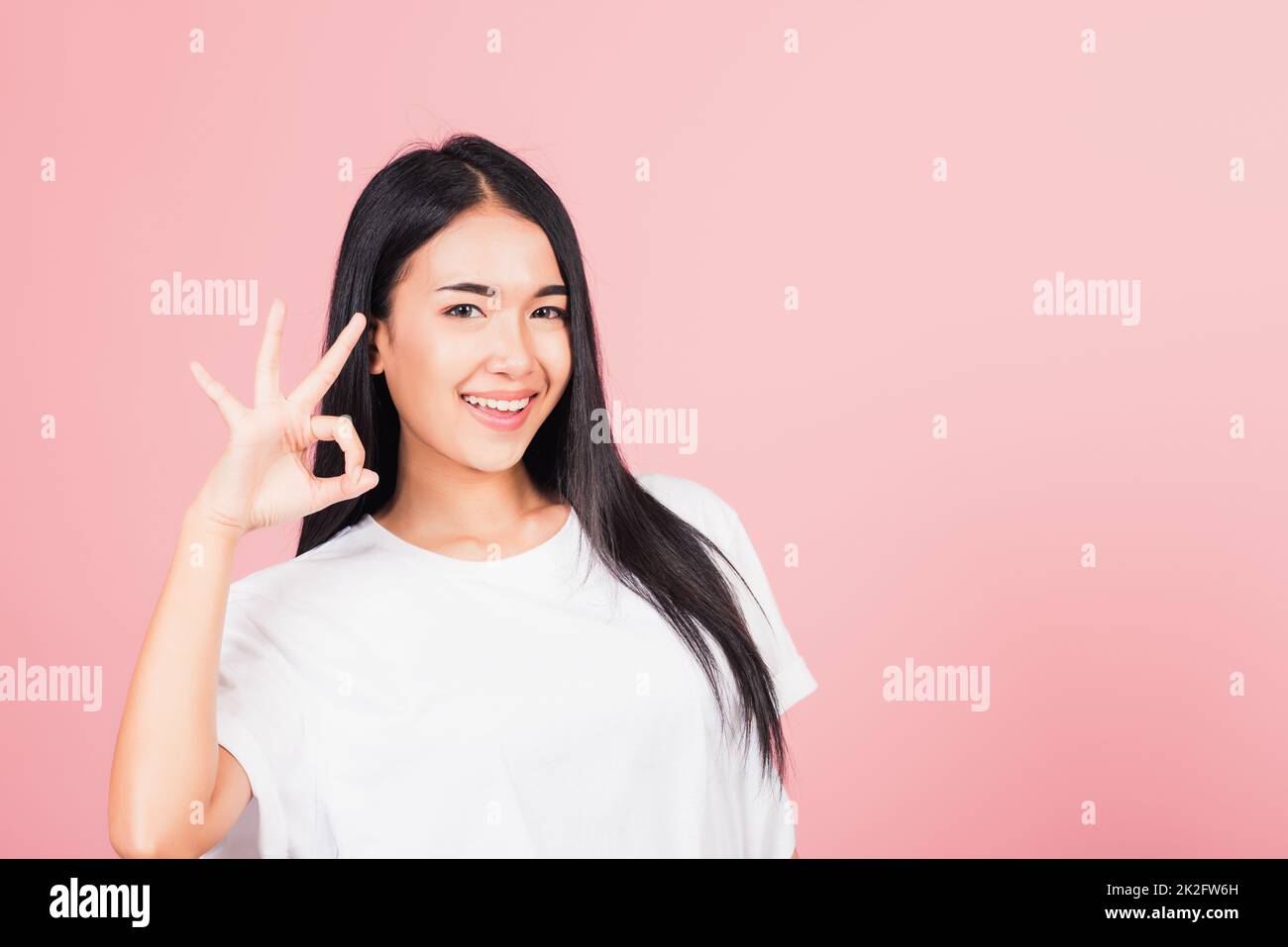 Die Frau stand und machte ein Zeichen mit dem Finger, um zuzustimmen Stockfoto