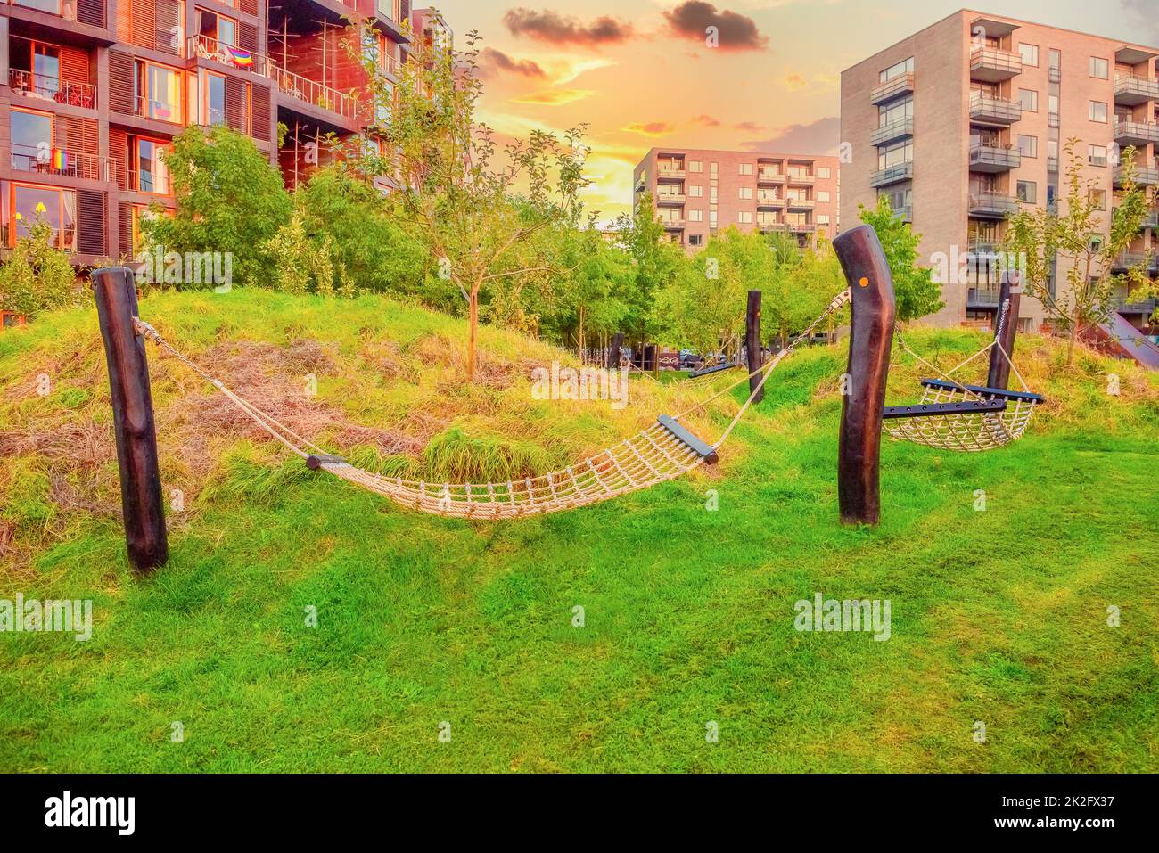 Hängematten auf Holzpfosten auf grünem Gras stehen auf dem Hof in der Nähe der Tietgen Studentenhalle Tietgenkollegiet in Kopenhagen, Dänemark Stockfoto