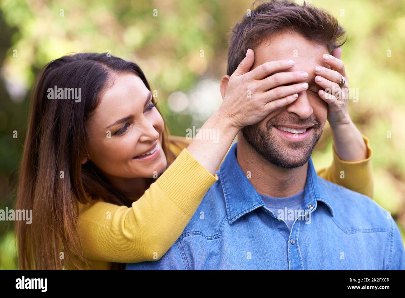 Die Freuden der Überraschungen. Aufnahme eines glücklichen jungen Paares, das draußen verspielt ist. Stockfoto