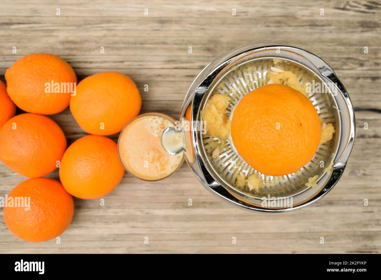 Draufsicht auf eine Orange beim Entsaften mit einem elektrischen Zitruspresse Stockfoto