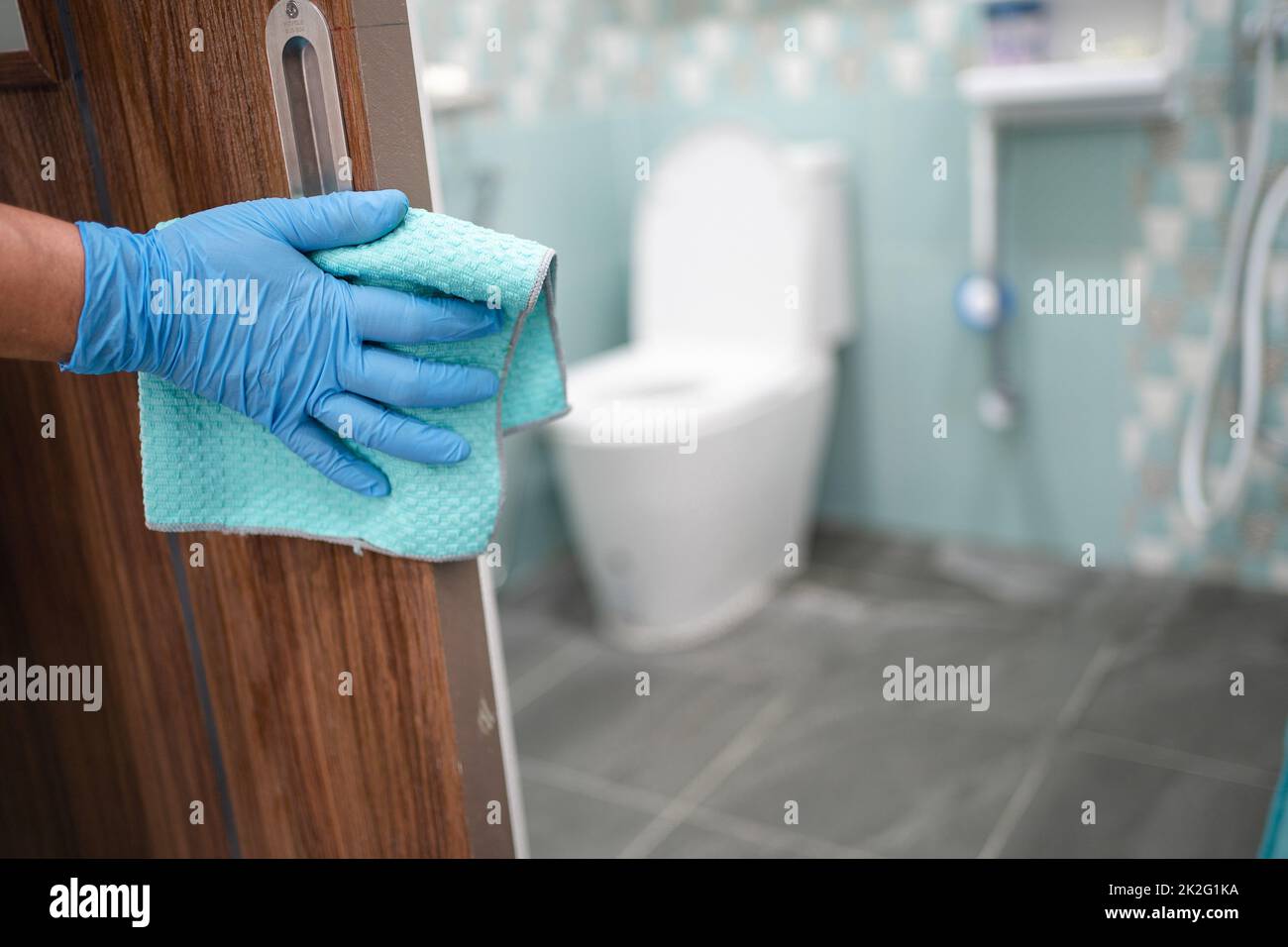 Reinigung Tür toliet Griff auf der Toilette mit Alkohol und weichen Tuch im Büro und zu Hause zum Schutz covid 19 Coronavirus Stockfoto