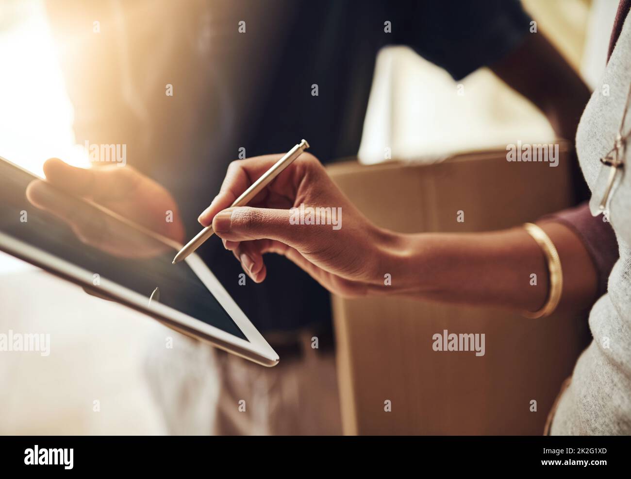 Digitale Signaturen sind die Lösung. High-Angle-Aufnahme einer unkenntlichen Frau, die für eine Heimlieferung unterschrieben hat. Stockfoto