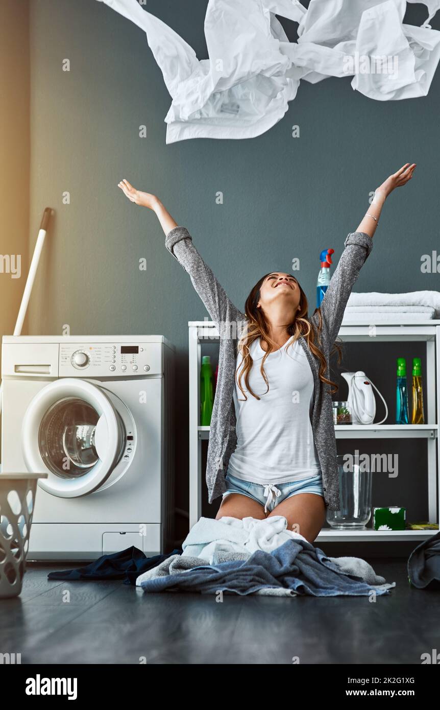 Das tolle Gefühl sauberer Wäsche. Aufnahme einer jungen attraktiven Frau, die ihre Wäsche zu Hause in die Luft wirft. Stockfoto