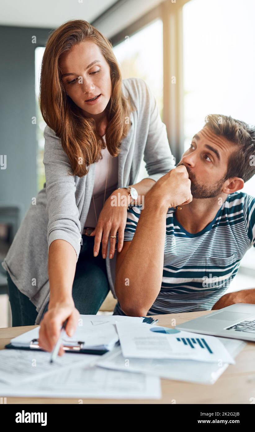 Ich Frage mich immer, wie sie das macht. Aufnahme eines liebevollen jungen Paares, das an seinem Haushaltsbudget arbeitet. Stockfoto