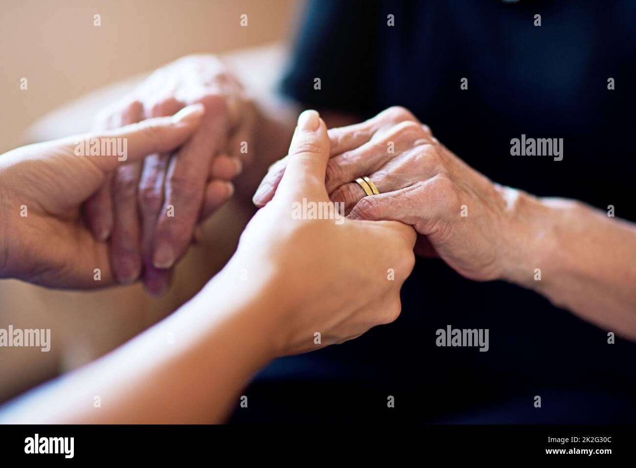 Ich bin für Sie da. Zugeschnittene Aufnahme einer Person, die eine ältere Frau in den Händen hält. Stockfoto