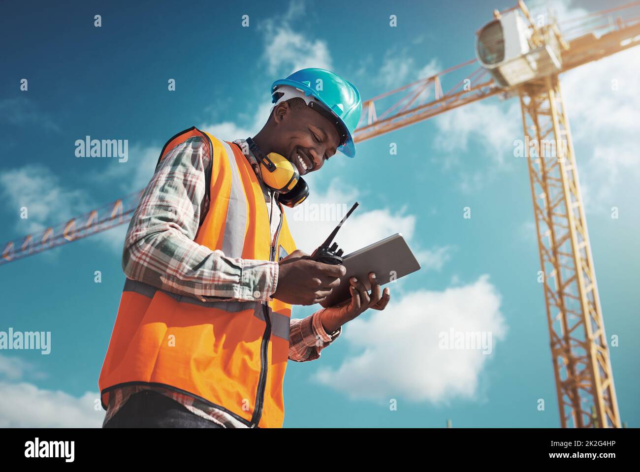 New Age Tech für New Age Konstruktion. Aufnahme eines jungen Mannes mit einem digitalen Tablet während der Arbeit auf einer Baustelle. Stockfoto