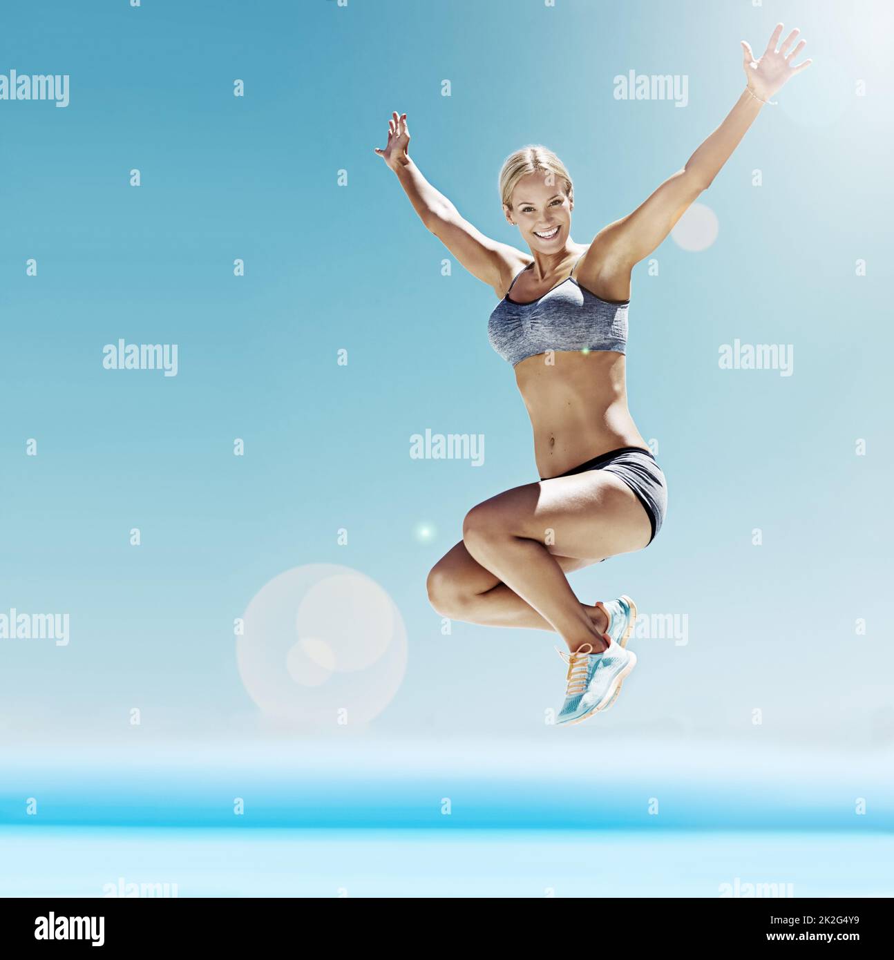 Voller Energie und Begeisterung. Aufnahme einer jungen Frau im Trainingsgerät, die in der Luft springt. Stockfoto