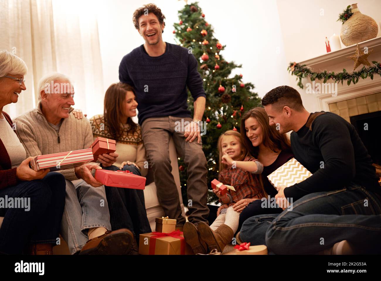 Die Familienzeit ist das größte Geschenk von allen. Aufnahme einer Familie mit mehreren Generationen, die zu Weihnachten Geschenke austauscht. Stockfoto
