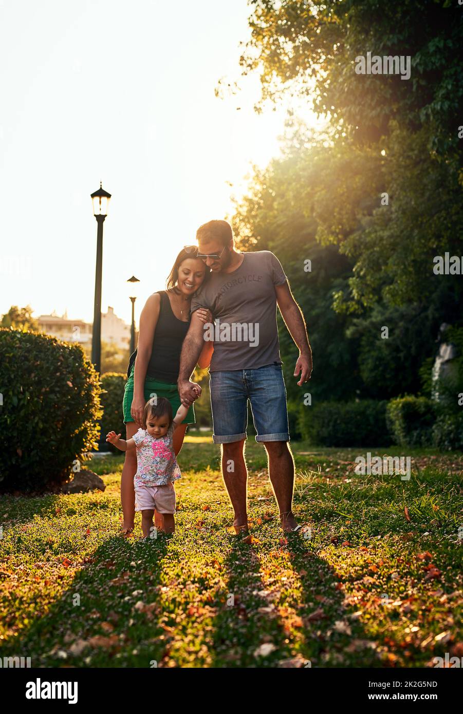 Zwei plus eins entspricht Familie zu uns. Aufnahme einer jungen Familie im Freien. Stockfoto