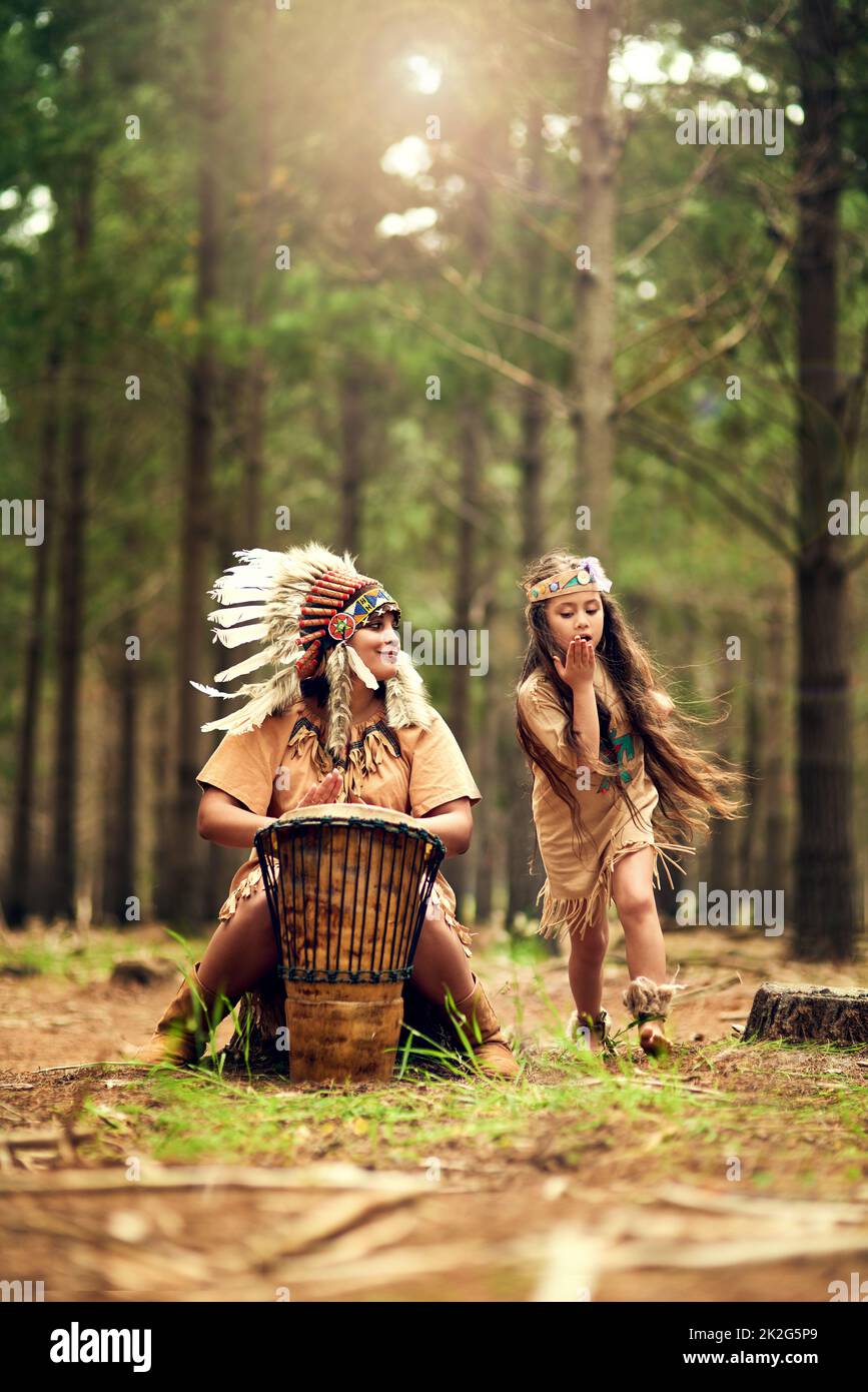 Spaß in der Natur. Aufnahme einer jungen Frau, die eine Trommel schlug, während sie mit ihrer Tochter im Wald dressup spielte. Stockfoto