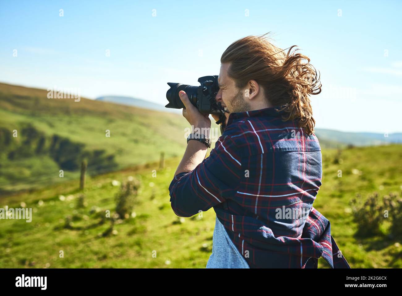 Gehen Sie in die Natur und Sie werden Schönheit finden. Aufnahme eines Mannes, der mit seiner Kamera im Freien fotografiert. Stockfoto