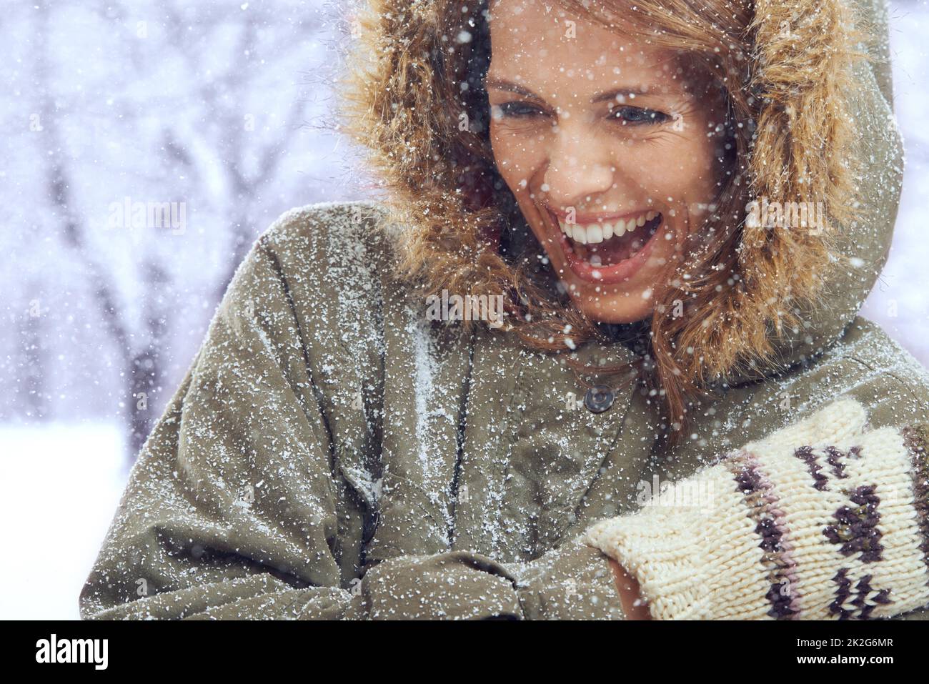 Den ersten Schneefall lieben. Aufnahme einer attraktiven Frau, die sich draußen im Schnee amügt. Stockfoto