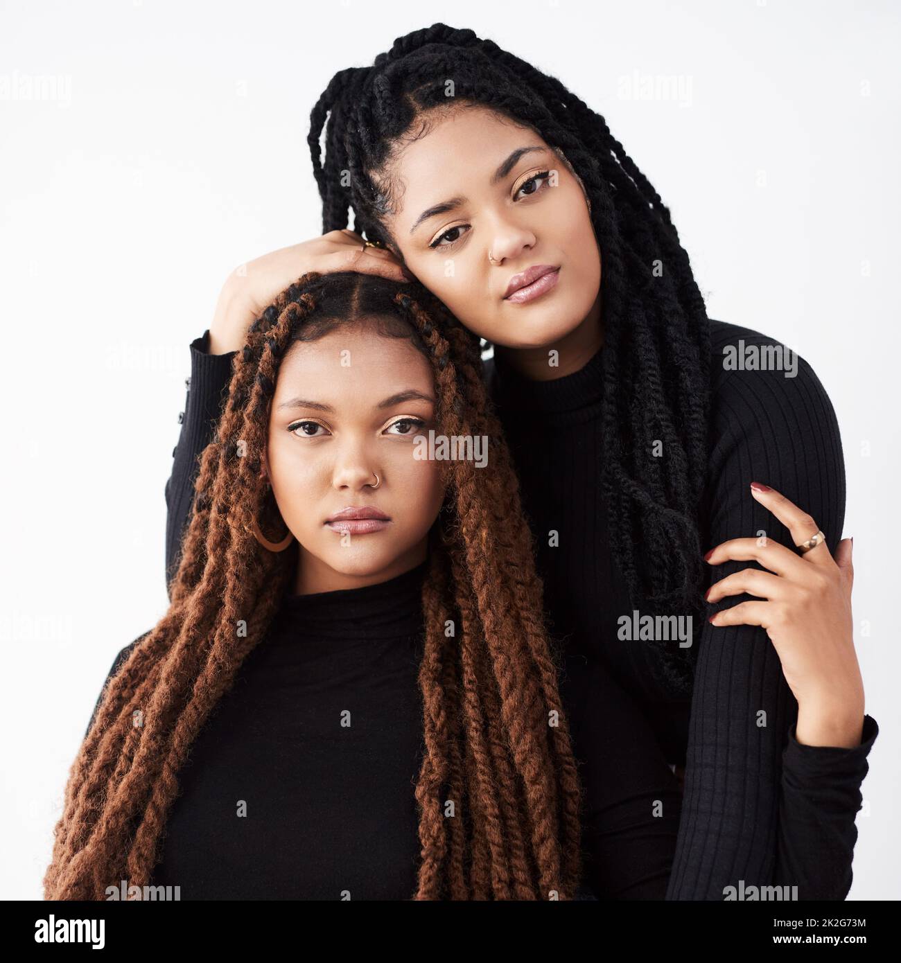 Sich mit ihrer Mode heftig zu fühlen. Studioaufnahme von zwei schönen jungen Frauen, die vor einem grauen Hintergrund posieren. Stockfoto