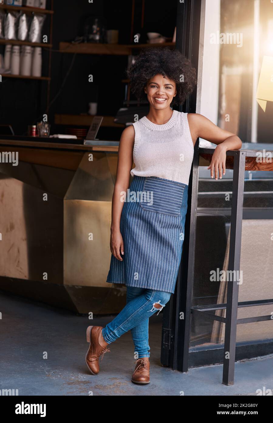 Halten Sie an Ihrem Unternehmergeist fest. Porträt einer selbstbewussten jungen Geschäftsbesitzerin, die vor der Tür ihres Cafés posiert. Stockfoto