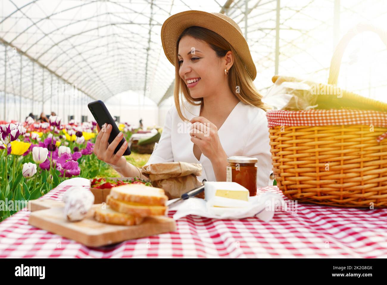 Technologie- und Lifestyle-Konzept. Mädchen teilt online ihre Picknick-Erfahrung auf einer Videokonferenz mit ihren Freunden. Stockfoto