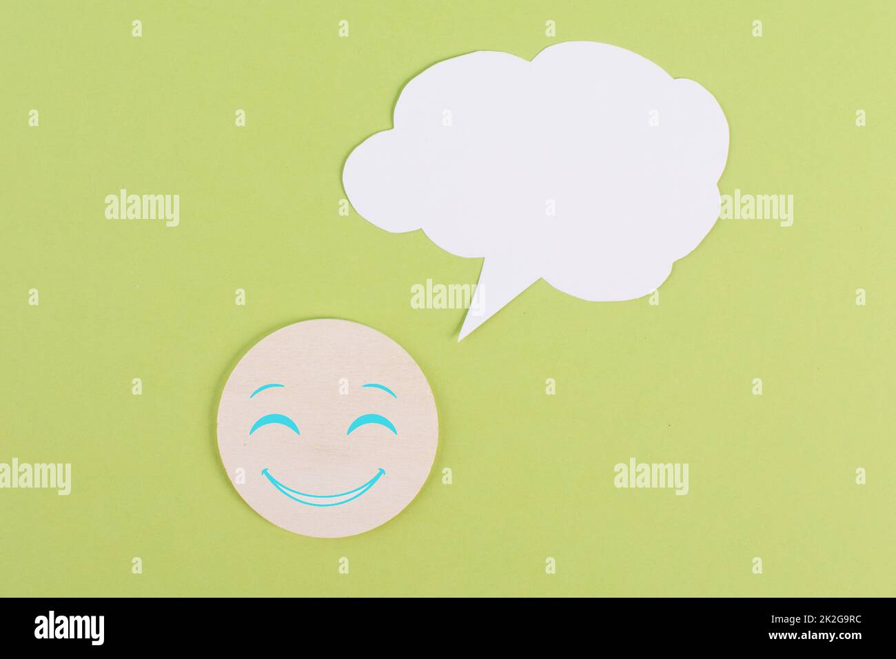 Lächelndes Gesicht mit einer Sprechblase, Bewertung, positives Feedback, Kundenerfahrung, Botschaft, Sprechende Wolke, grüner Hintergrund, Kopierbereich für Text Stockfoto