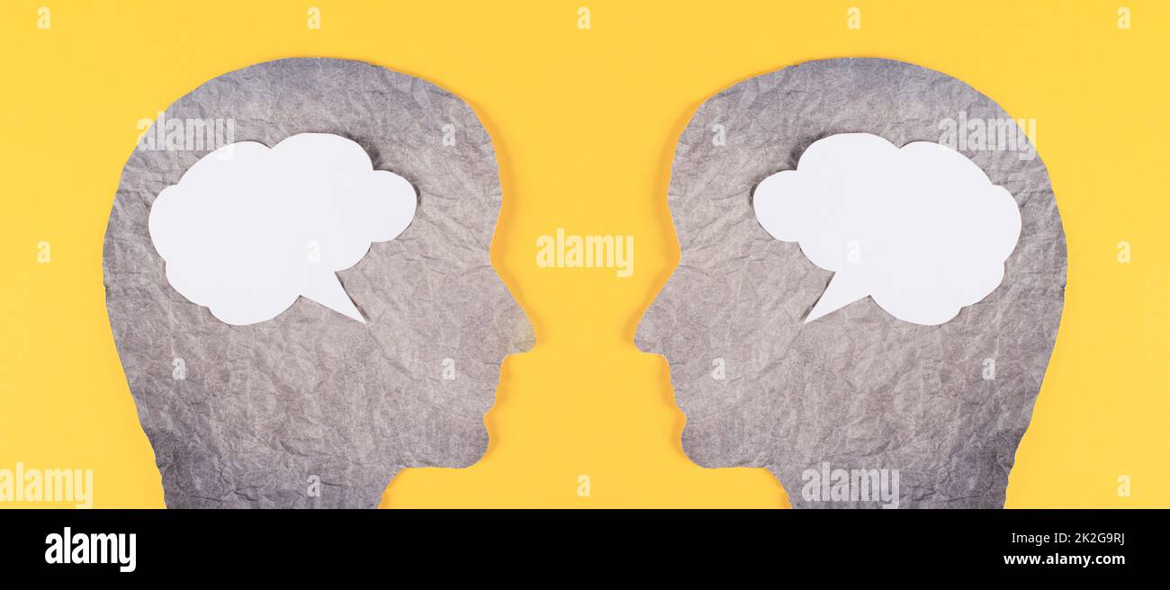Silhouette aus zwei Gesichtern, Sprachblase in weißer Farbe, Kopierraum für Text, Kommunikation, Meinungs- und Diskussionsfähigkeit, Redefreiheit, Gesprächspartner, grüner Hintergrund Stockfoto