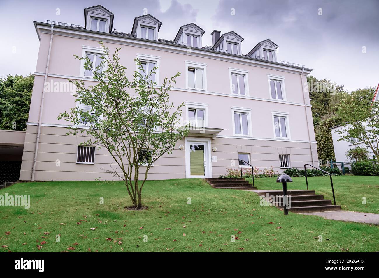 Moderne Stadtarchitektur, neu renovierter Apartmentbau, Apartmentgebäude in einer ruhigen Wohngegend mit Grünflächen Stockfoto