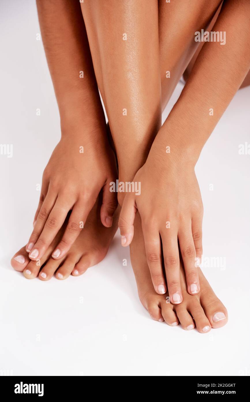 Luxuriöse Haut. Studioaufnahme einer nicht erkennbaren jungen Frau mit Beinen und Händen vor grauem Hintergrund. Stockfoto