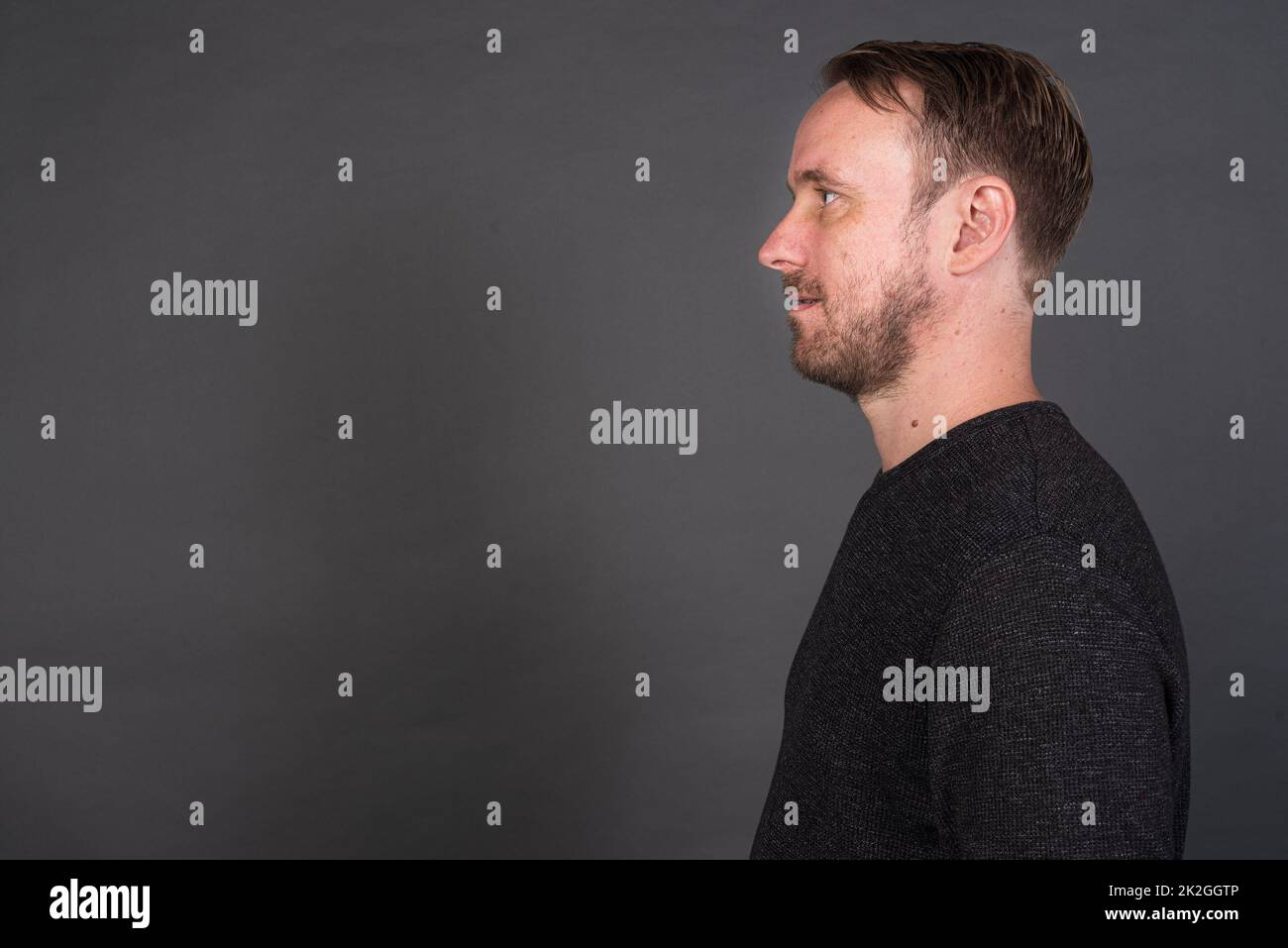 Studio-Porträt des blonden kaukasischen Mannes mit grauem Hemd Stockfoto