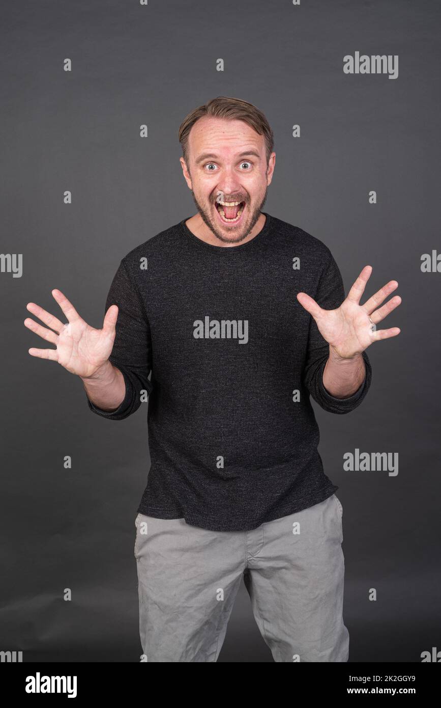 Studio-Porträt des blonden kaukasischen Mannes mit grauem Hemd Stockfoto